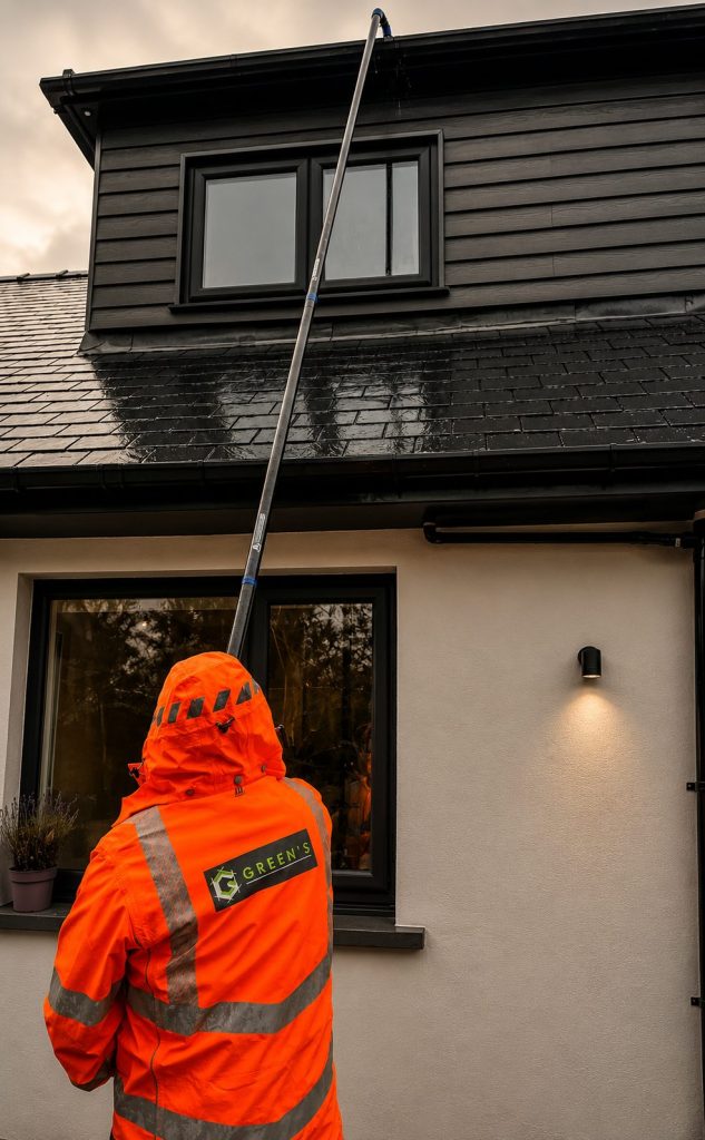 Worker cleaning modern house under rain
